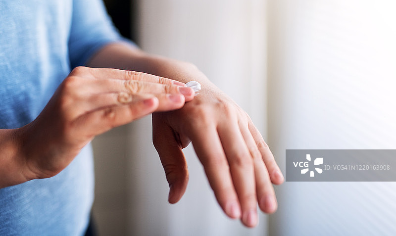 室内涂抹护手霜的女子图片素材