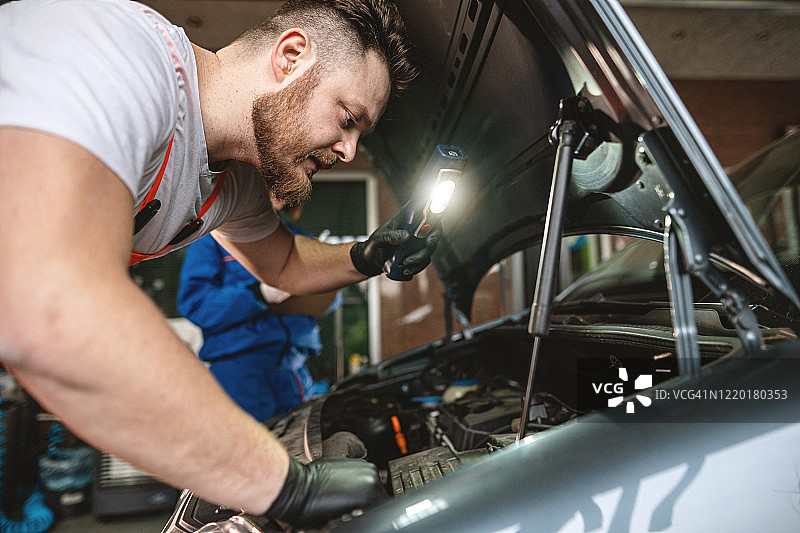 在他的修理车间工作的胡须男人图片素材