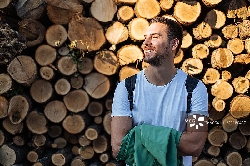 男游客站在一堆木头前图片素材