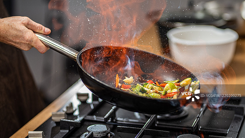 厨师在平底锅中烹饪蔬菜图片素材