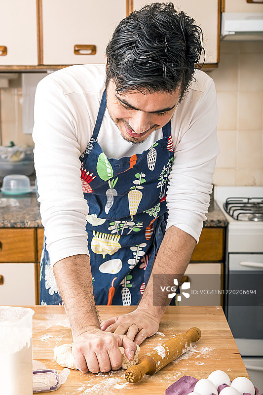 男人在厨房餐桌上揉面图片素材