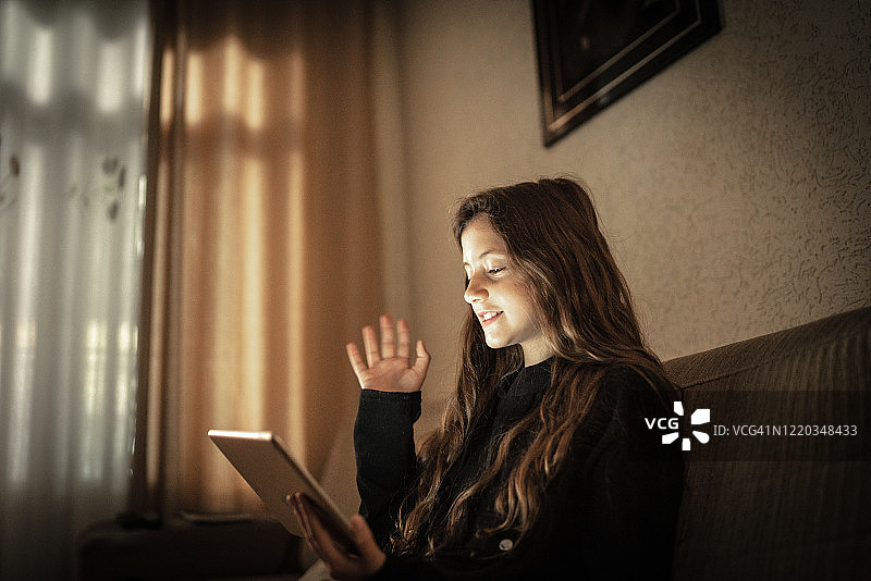 女孩在家用平板电脑视频通话图片素材