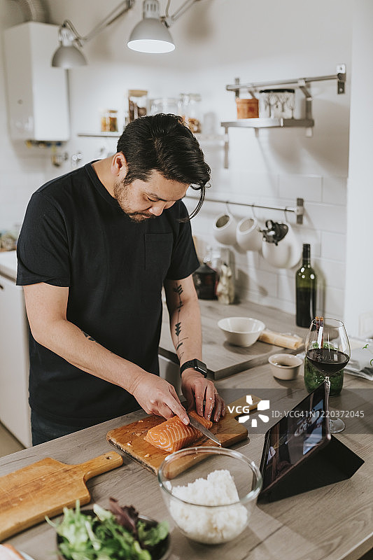 日本男人与女友视频通话时切割新鲜的三文鱼图片素材