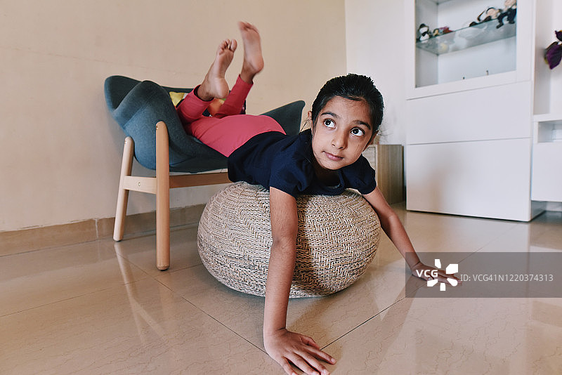 女孩在扶手椅和脚凳上玩耍图片素材