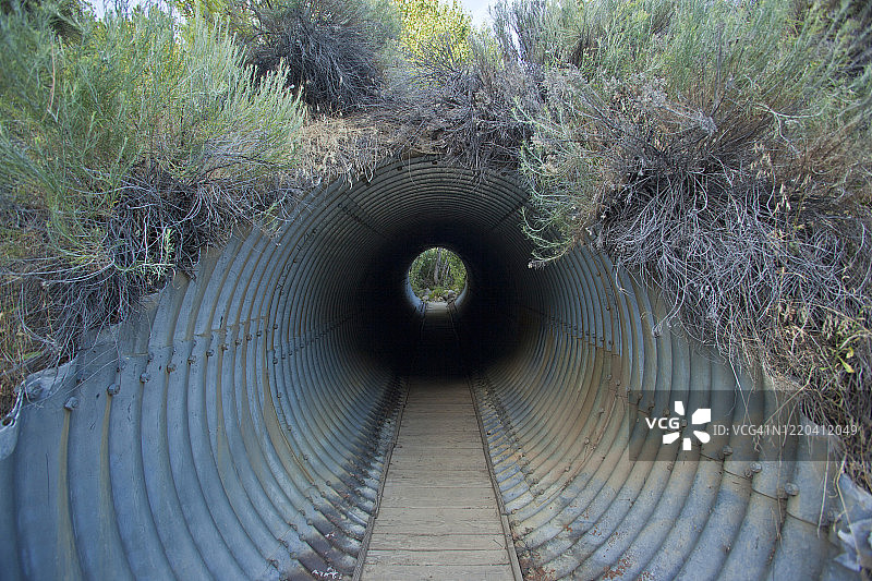 黑暗的排水隧道变成人行道，尽头没有灯光图片素材