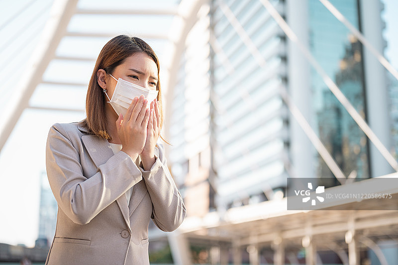 在城市户外戴着防护口罩的年轻亚洲商务女人图片素材