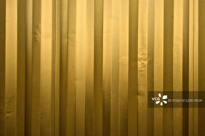 涂成金色的波纹金属运输集装箱的凹陷侧面图片素材