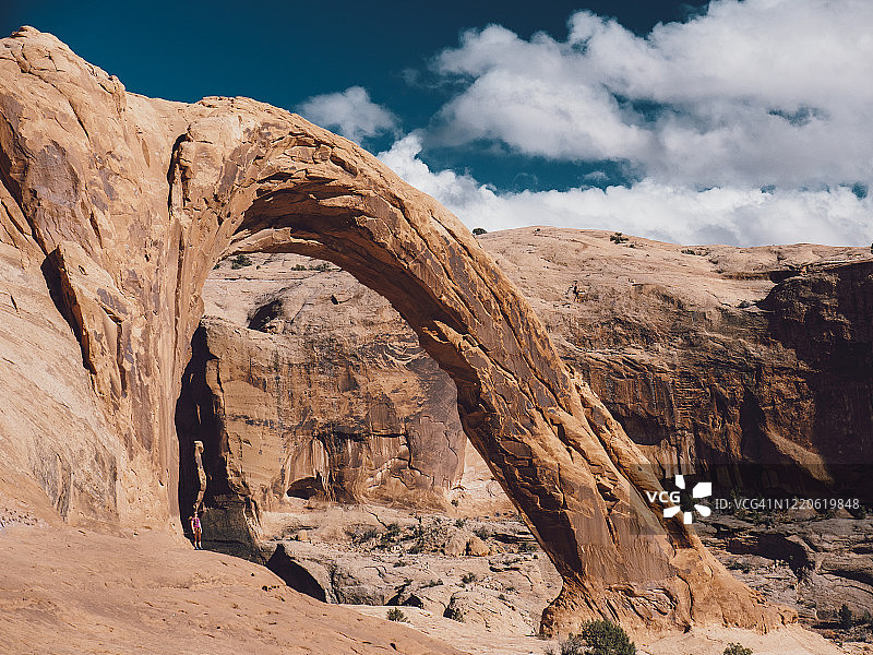 年轻女子站在犹他州摩押附近的电晕拱门附近图片素材