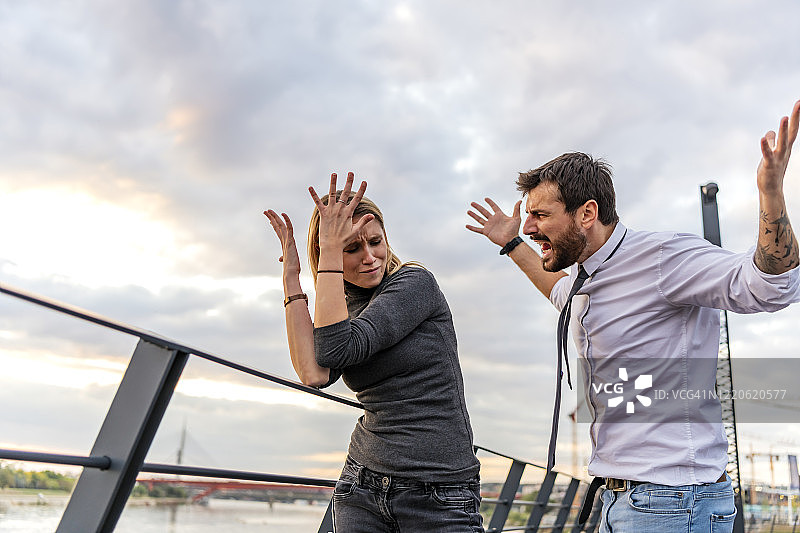 英俊男人在河边与女友争吵图片素材