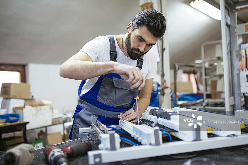 电工在车间维修电子元件图片素材