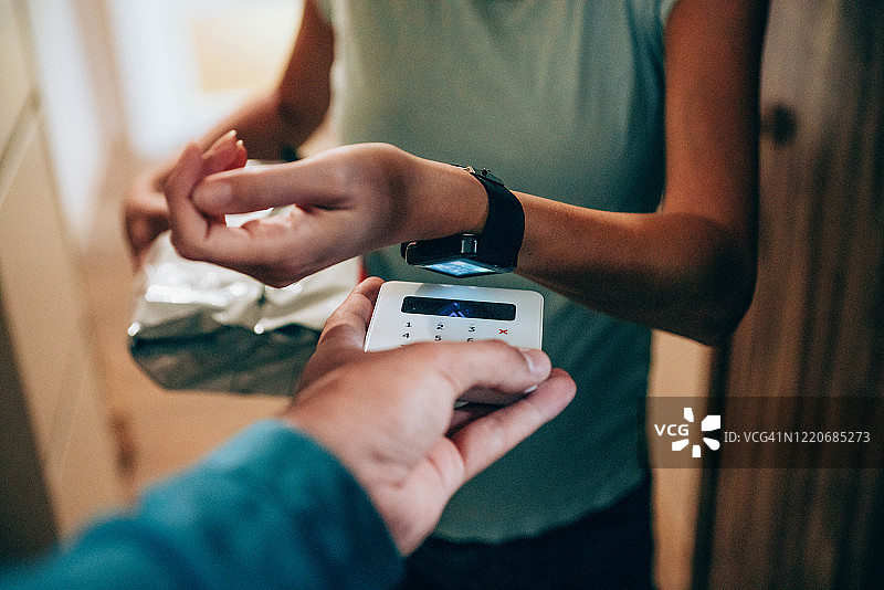 女人使用智能手表进行非接触式支付图片素材