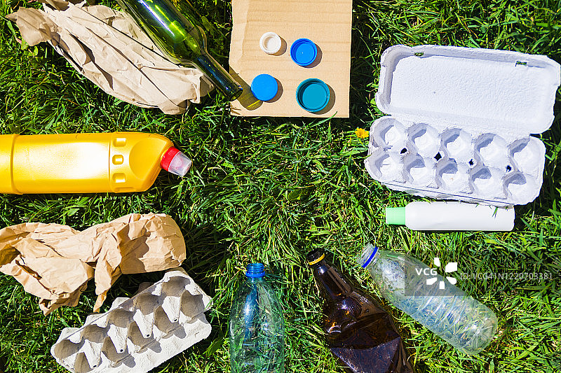 绿色草地上用于回收的各种垃圾图片素材