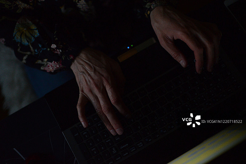 在家工作的女人，深夜在笔记本电脑上打字图片素材