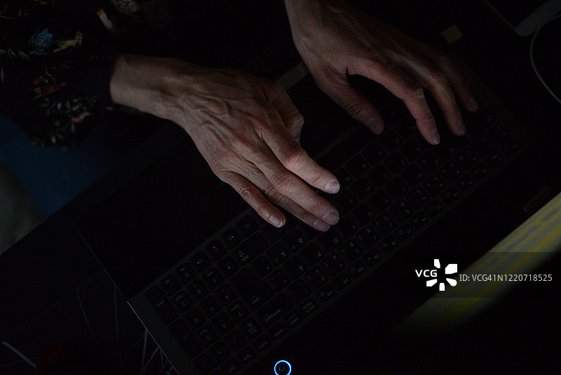 在家工作的女人，深夜在笔记本电脑上打字图片素材