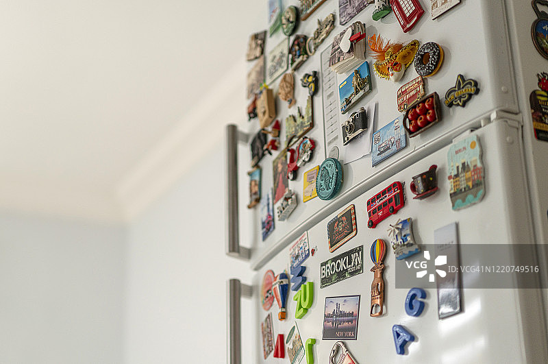 厨房冰箱上许多各式各样的纪念磁铁图片素材