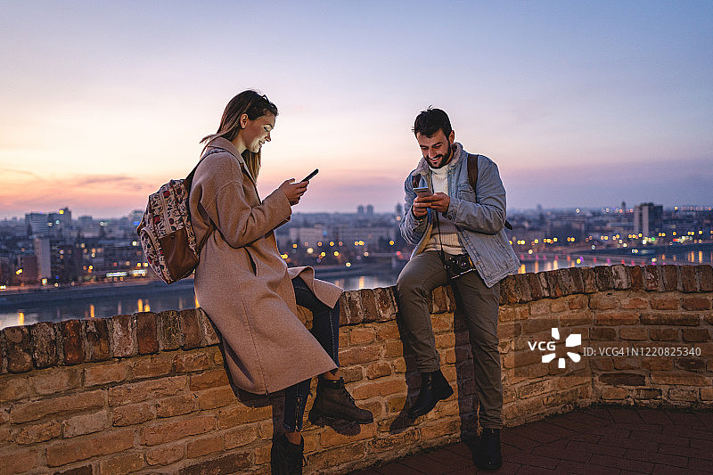 微笑的游客在使用手机图片素材