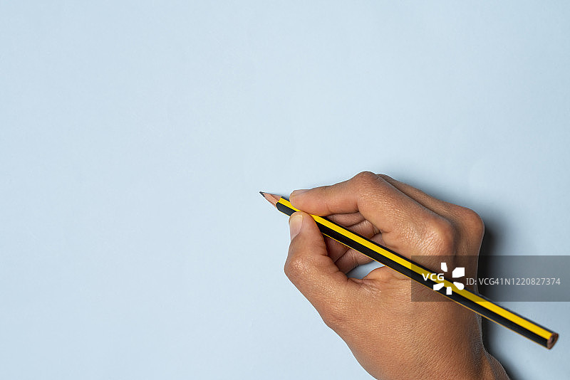 手握黄黑色铅笔图片素材