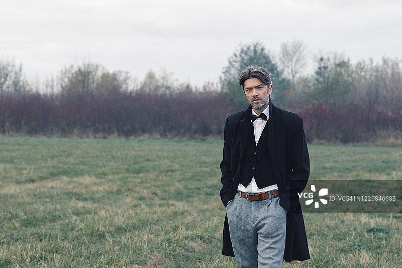 穿灰色西装的男人在大自然中摆姿势图片素材