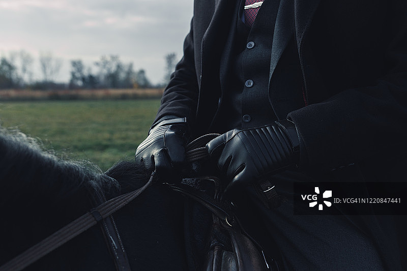穿着优雅西装骑在马上的男人图片素材