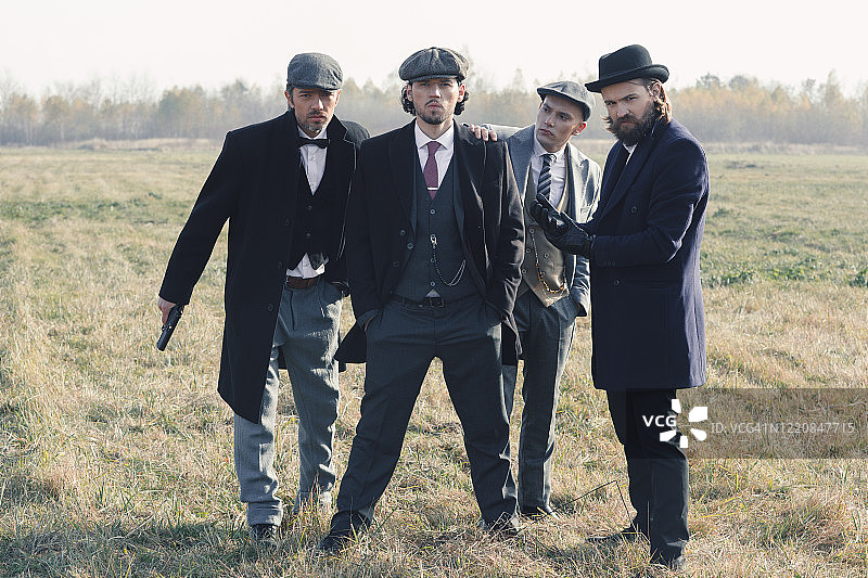 四个穿着旧式服装的绅士，手持武器图片素材