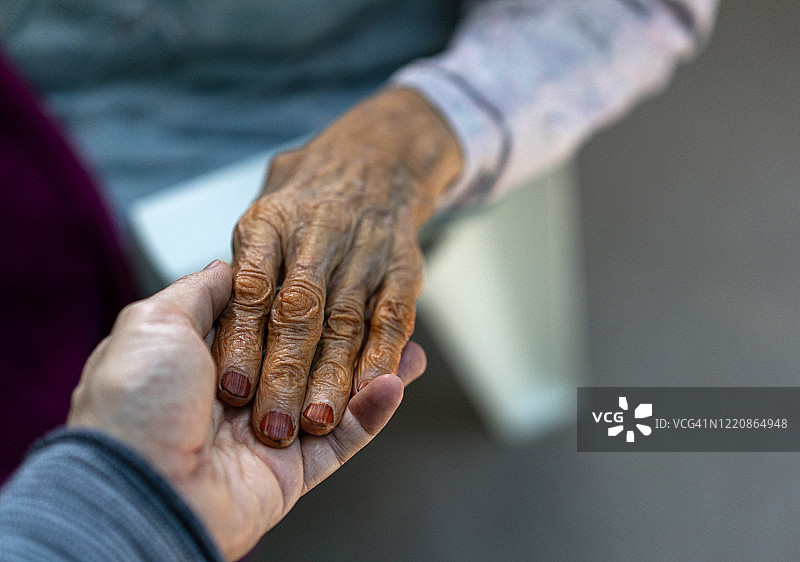 年轻男人握着祖母的手，特写镜头图片素材