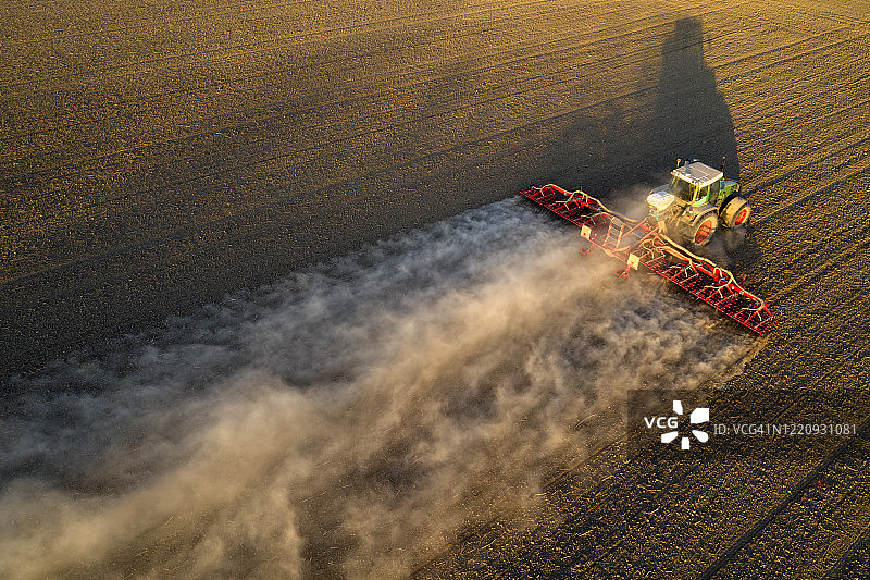 农用拖拉机在耕地上钻孔播种图片素材