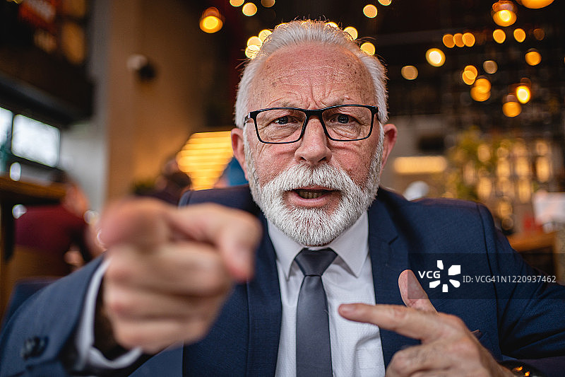 年长的男商人对着镜头大喊图片素材