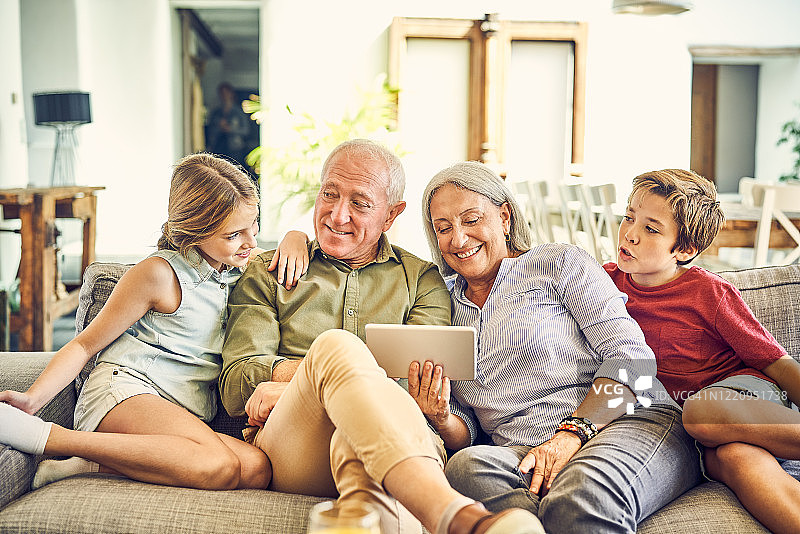祖父母向孙辈展示平板电脑图片素材