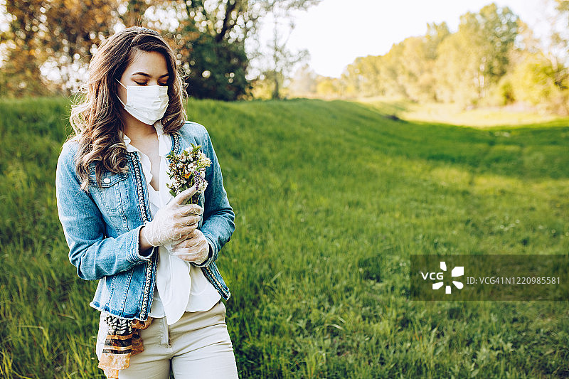 在自然环境中戴着防护口罩的女人图片素材