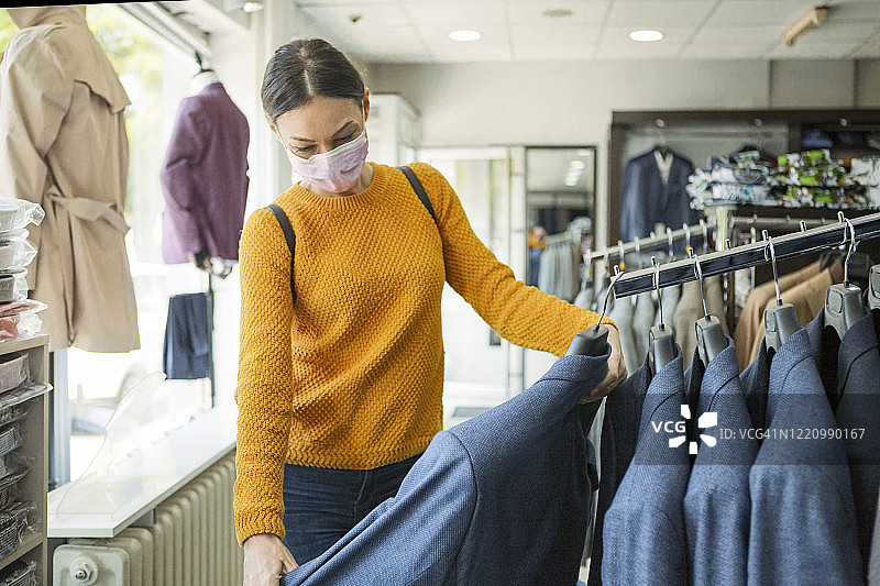 疫情期间戴防护口罩购物的年轻女子图片素材