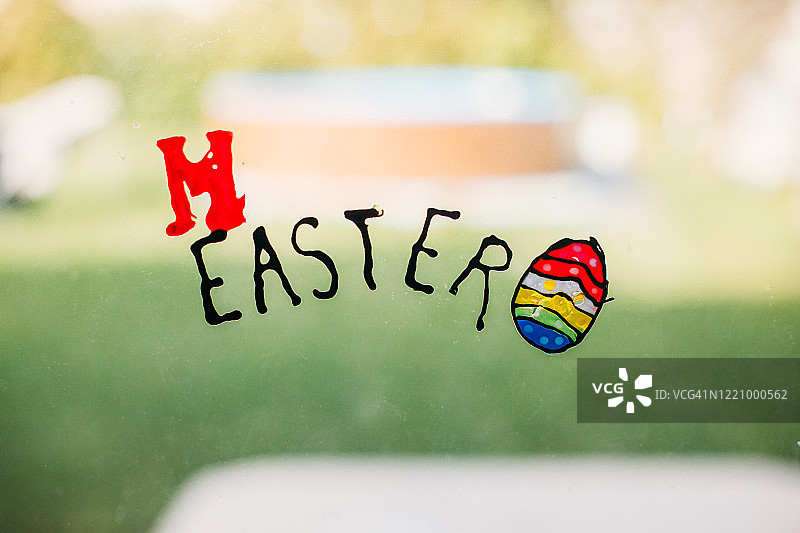 孩子们在玻璃窗上制作的复活节字母和彩色蛋图片素材