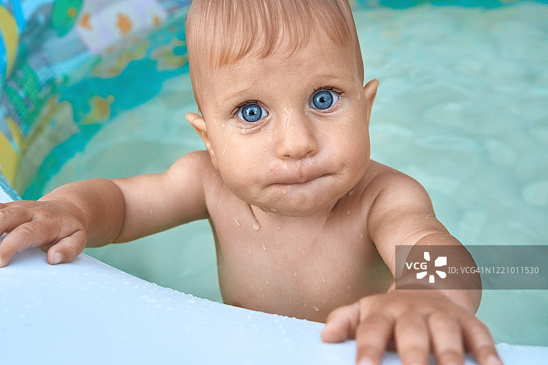 站在婴儿游泳池里的可爱一岁宝宝图片素材