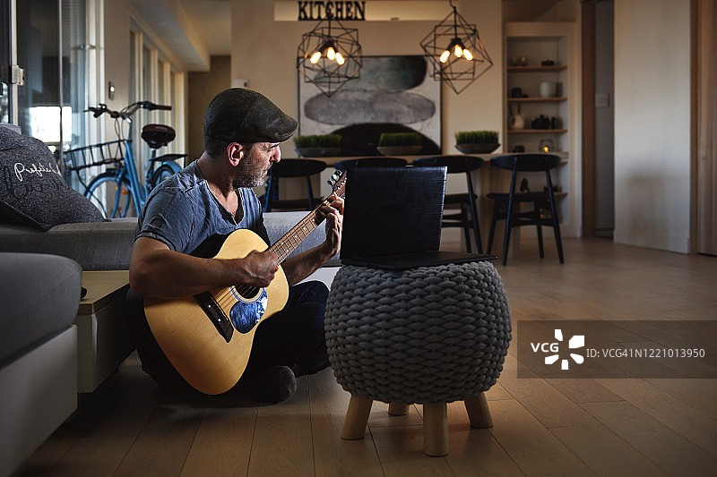 隔离中的中年男人参加线上吉他课程图片素材