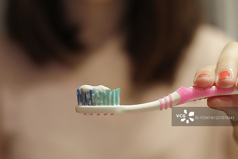 牙刷上挤着牙膏的女人图片素材