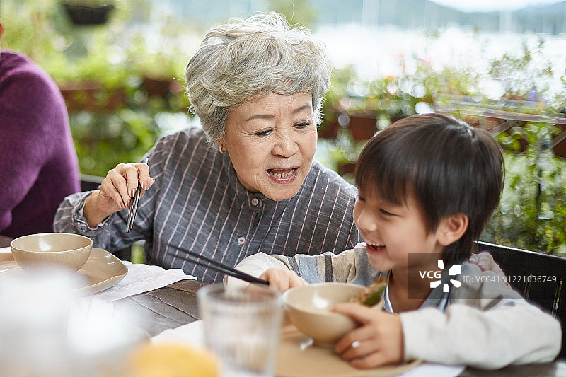 爱玩的中国奶奶和孙子一起吃饭图片素材