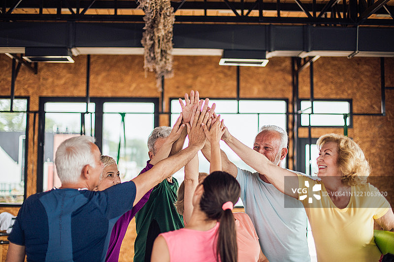 上完瑜伽课后击掌的快乐年长者图片素材
