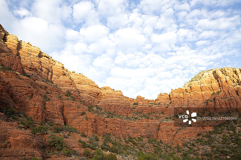 冬日下午亚利桑那州塞多纳红岩景观，蓝天中飘浮着蓬松的白云图片素材