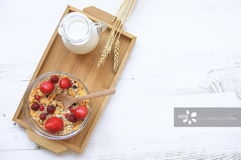 搭配新鲜红色浆果和牛奶的格兰诺拉麦片早餐图片素材