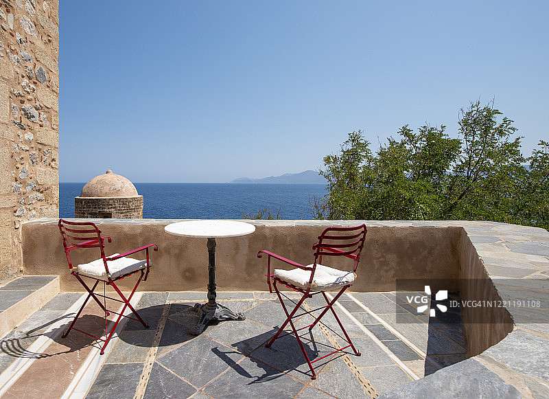 希腊伯罗奔尼撒莫奈姆瓦夏古老村庄阳台上的木椅和桌子图片素材