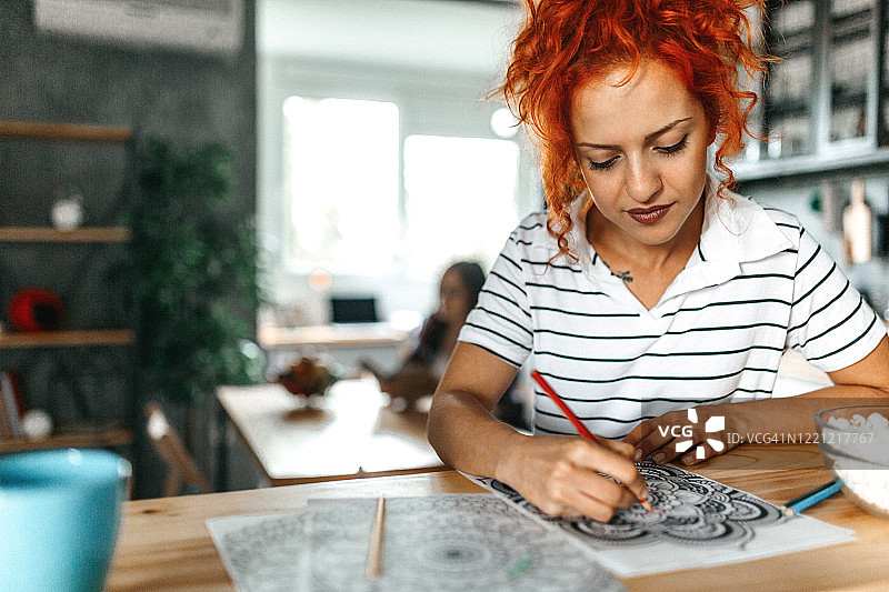 女人在成人涂色书上绘画图片素材