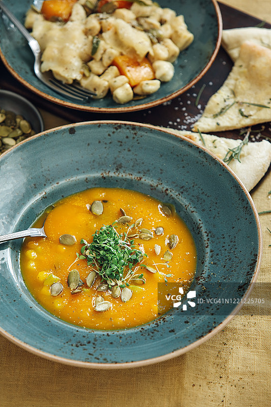 黄色桌布上的纯素南瓜胡萝卜汤图片素材