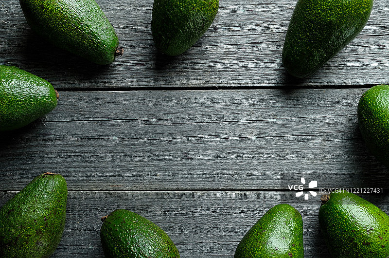 木桌上的几个绿色鳄梨图片素材