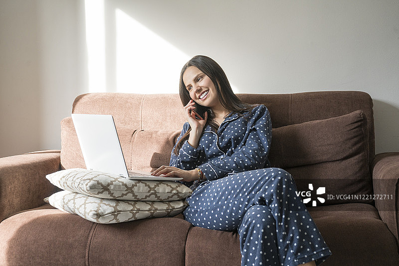 居家隔离期间在沙发上进行视频会议的女人图片素材