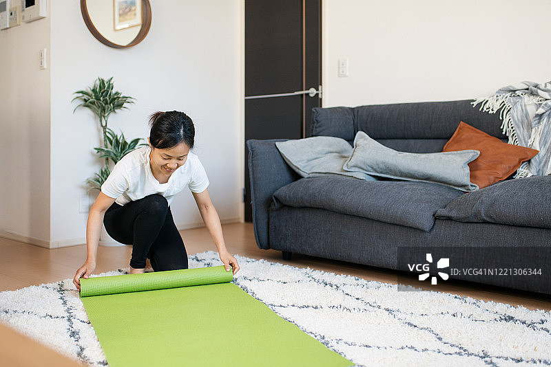 在家中铺开瑜伽垫的女人图片素材