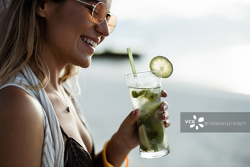 快乐女人在沙滩享受夏日鸡尾酒图片素材