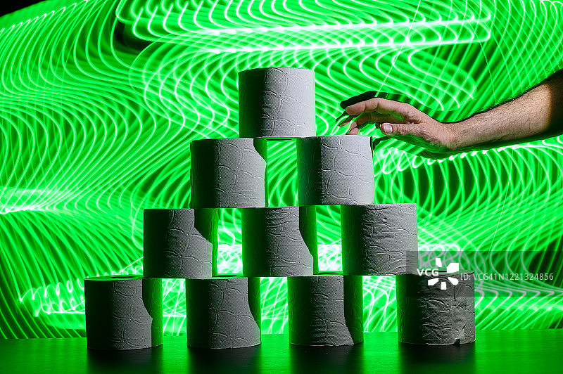 手拿卫生纸，背景为未来主义绿色线条图片素材