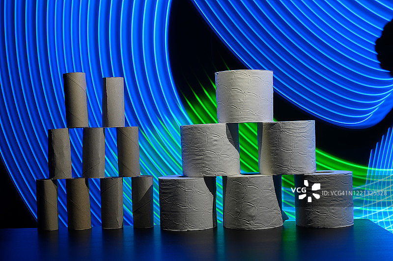 未来主义背景下，蓝色和绿色曲线勾勒的空与满卫生纸卷塔图片素材