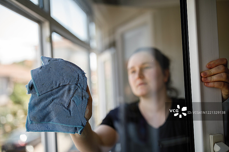 清洁窗户的年轻女子图片素材