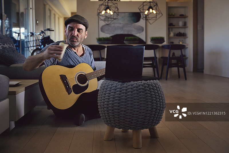 隔离中的中年男人参加线上吉他课程图片素材