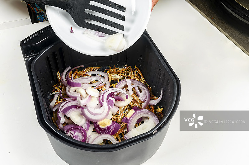 空气炸锅中的凤尾鱼和洋葱图片素材